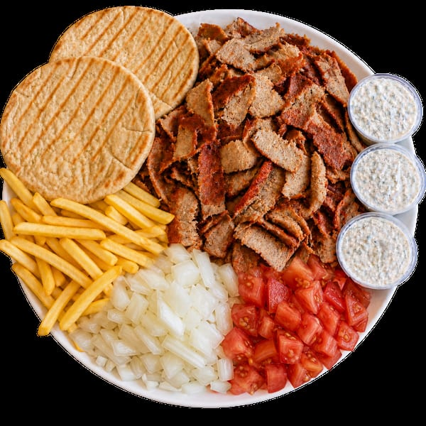 A large platter of gyro meat, pita bread, french fries, diced onions, tomatoes, and tzatziki sauce.