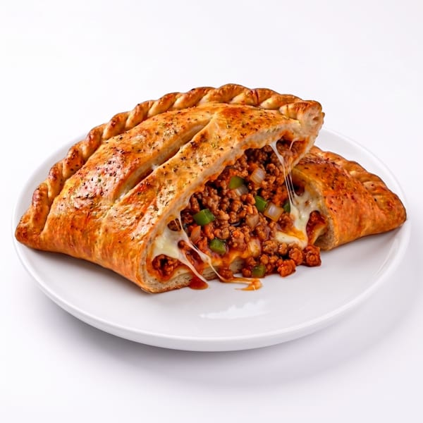 A golden-brown calzone, sliced open to reveal a filling of ground meat, cheese, and vegetables.